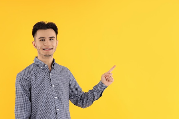 Um cara atraente com uma camisa em fundo amarelo