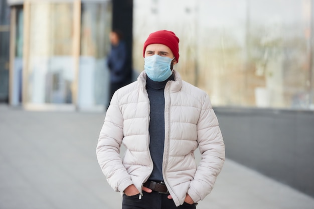 Um cara com uma máscara no rosto por causa da pandemia na rua