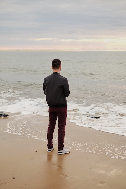 Um cara jovem e bonito no fundo do mar fica ao vento