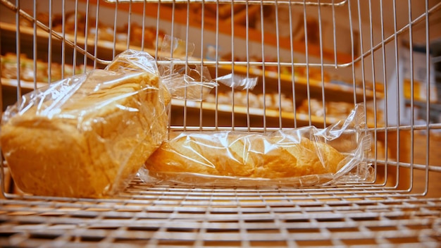 Um carrinho de supermercado no supermercado comprando pão diferente