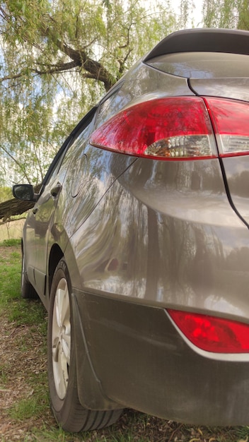 Um carro bege com uma luz traseira vermelha e luzes de freio traseiras