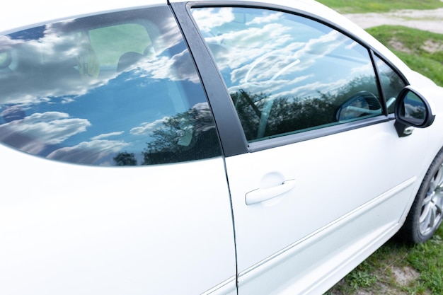 Um carro branco com a porta aberta e a janela aberta.