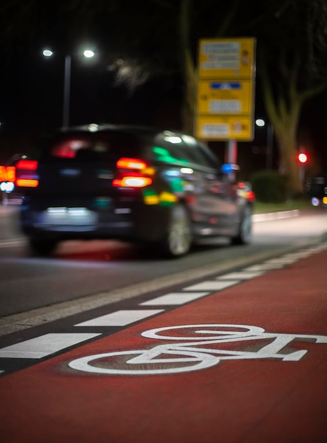 Um carro está estacionado em um caminho vermelho que diz 'ciclovia' nele.