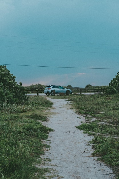 Foto um carro estacionado em uma estrada com um céu azul ao fundo