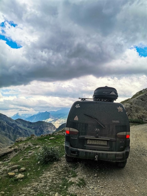 Um carro no fundo de uma vista deslumbrante das montanhas no daguestão cáucaso rússia 2021