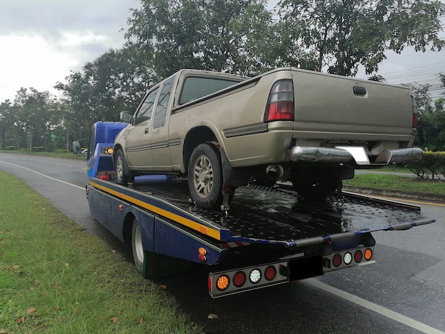 Foto um carro quebrou e sendo puxado para dentro do caminhão de reboque