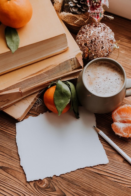 Um cartão postal vazio ao lado de livros e tangerinas Planos e sonhos para o ano novo espaço para texto