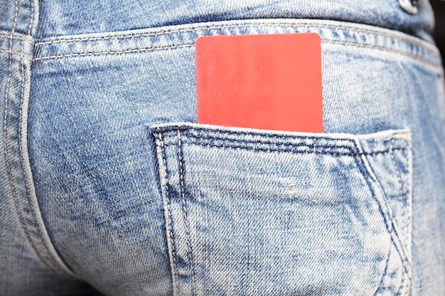 Um cartão vermelho no bolso de trás de uma calça jeans