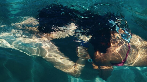 Foto um casal a beijar-se na piscina.