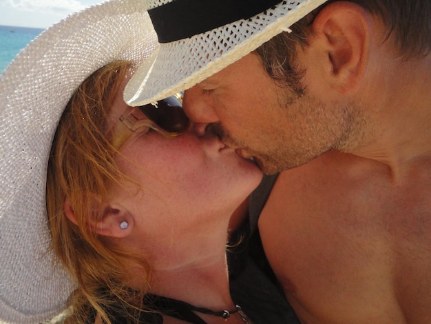 Foto um casal a beijar-se na praia.