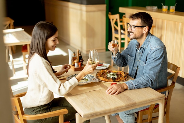 Um casal a desfrutar de um jantar romântico num restaurante aconchegante a celebrar com um brinde.