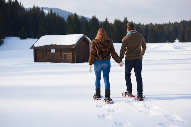 Foto um casal a divertir-se e a andar de sapatos de neve.