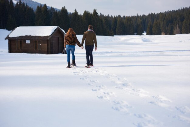 Foto um casal a divertir-se e a andar de sapatos de neve.