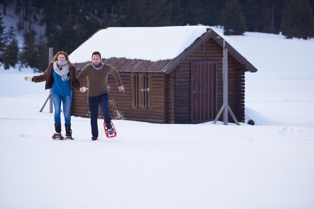 Foto um casal a divertir-se e a andar de sapatos de neve.