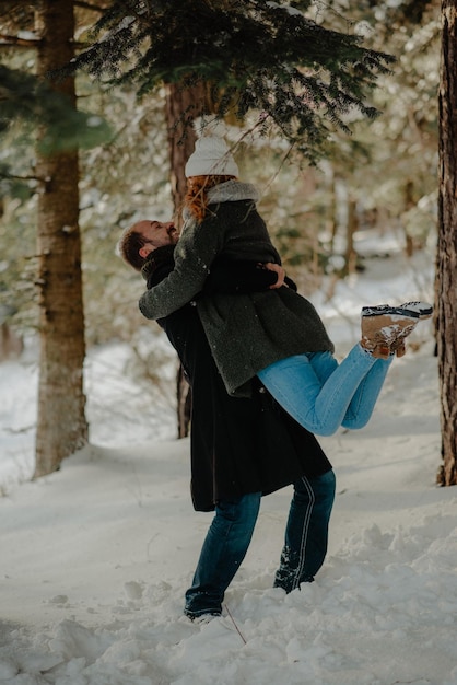 Um casal abraçando-se enquanto está de pé em uma terra coberta de neve