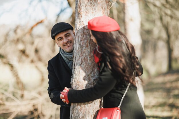 Foto um casal abraçando uma árvore em um parque