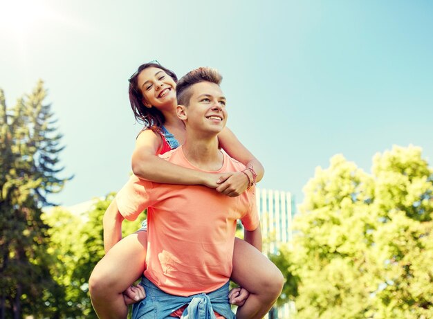 Foto um casal adolescente feliz a divertir-se no parque de verão.