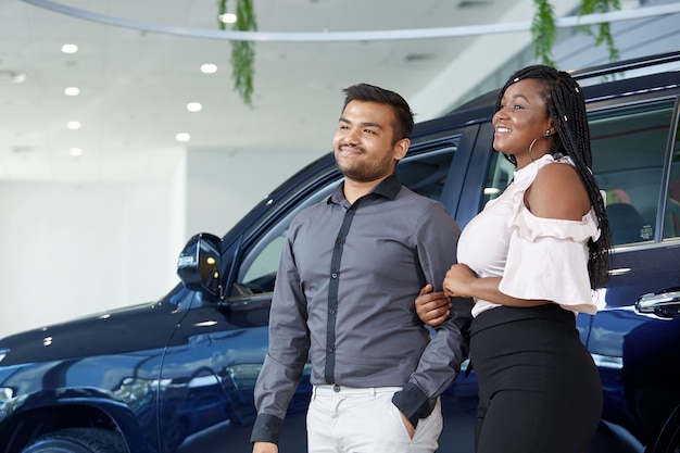 Foto um casal afro-americano está pensando em comprar um carro em uma concessionária