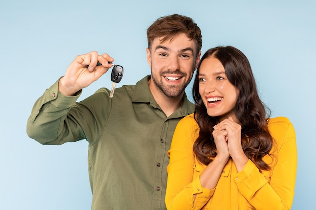 Foto um casal alegre com chaves de carro novas animado para uma viagem de carro