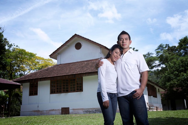 Foto um casal alegre de pé na relva.