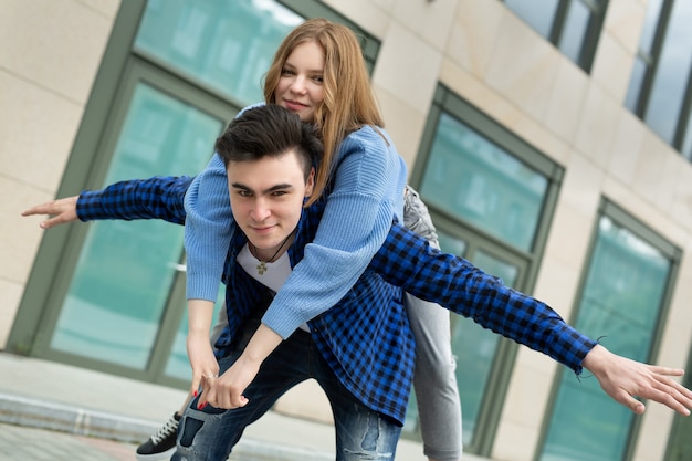 Um casal alegre e brincalhão está brincando, gesticulando com as asas de um avião, sorrindo