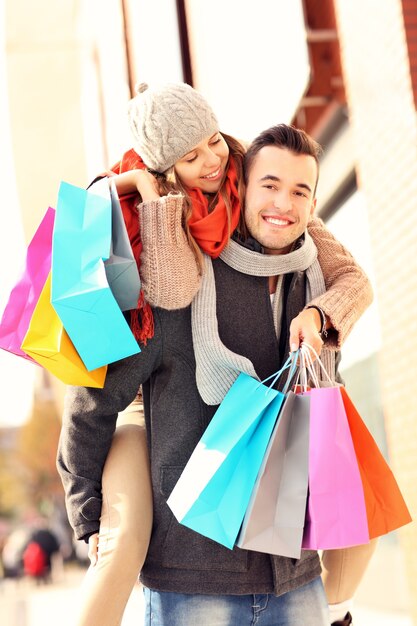 um casal alegre fazendo compras na cidade