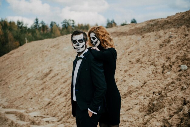 Foto um casal apaixonado está sentado abraçando-se contra o fundo das montanhas celebrando o dia das bruxas em costum