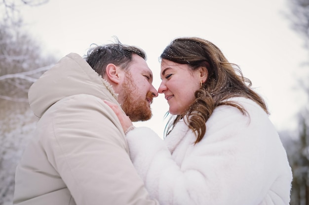 Um casal apaixonado num campo de inverno coberto de neve, felizes juntos.