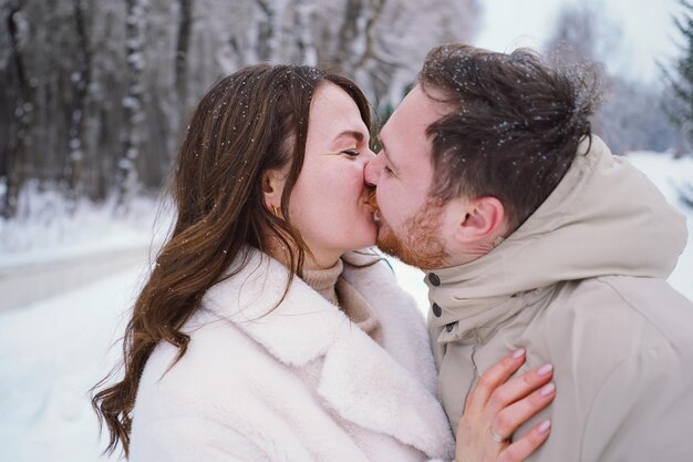 Foto um casal apaixonado num campo de inverno coberto de neve, felizes juntos.