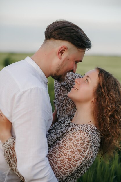 Um casal apaixonado num campo verde de trigo