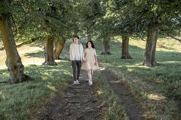 Um casal apaixonado, um cara e uma garota estão andando por um lindo jardim