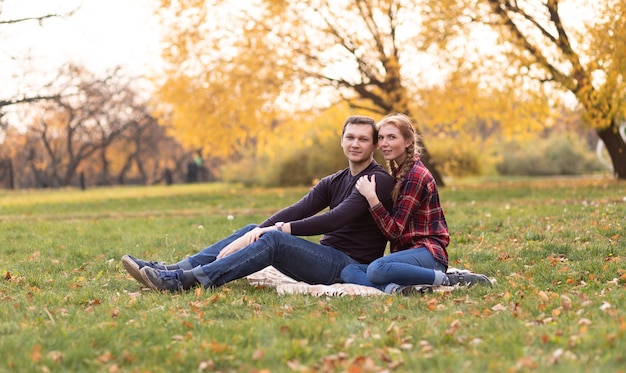 Um casal apaixonado, um cara e uma garota estão sentados em um parque de outono