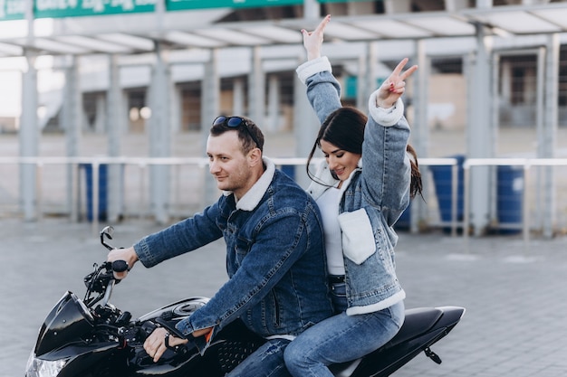 Um casal apaixonado, um rapaz e uma rapariga numa moto desportiva preta, num primeiro encontro