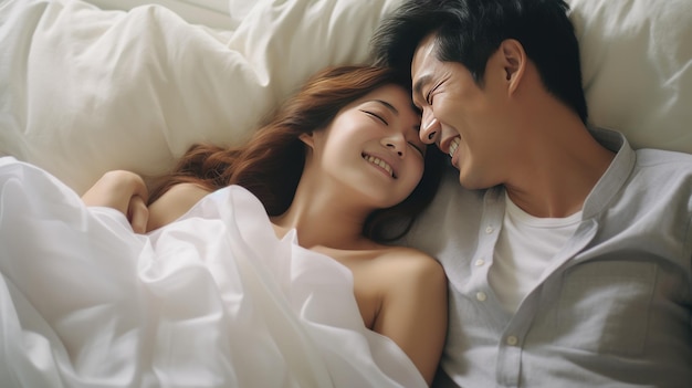 Um casal asiático feliz na cama em casa, conceito de amor e romance.
