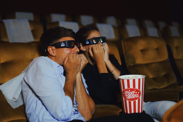 Um casal assustado a ver um filme no cinema.