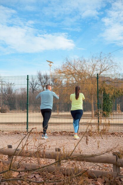 Um casal ativo em roupas atléticas se esticando juntos ao ar livre