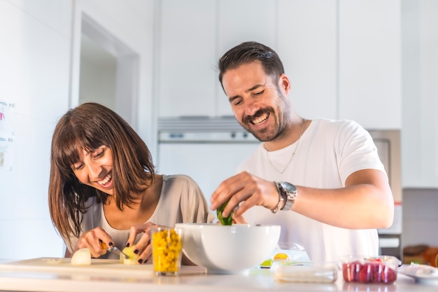 Um casal caucasiano cozinhando em casa, cozinhando em confinamento, cozinhando com a família.