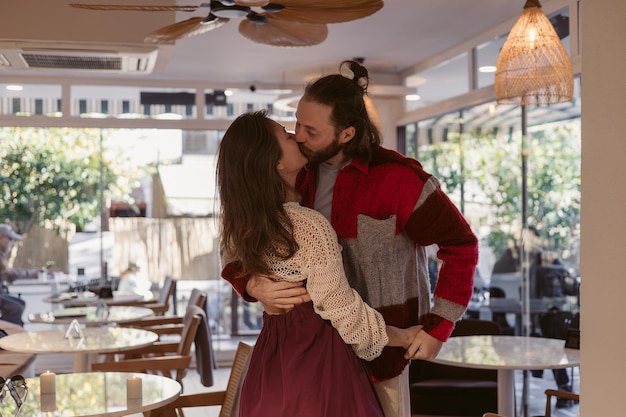 Um casal compartilha um momento íntimo em um café aconchegante durante uma tarde ensolarada