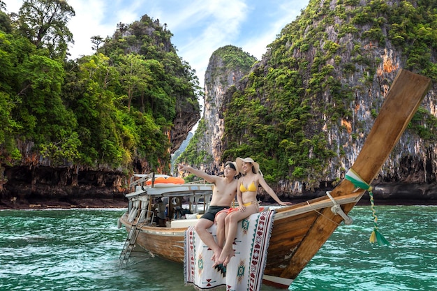 Um casal de amantes asiáticos viaja e relaxa em sua viagem de lua de mel no barco arborizado em Krabi Phi Phi