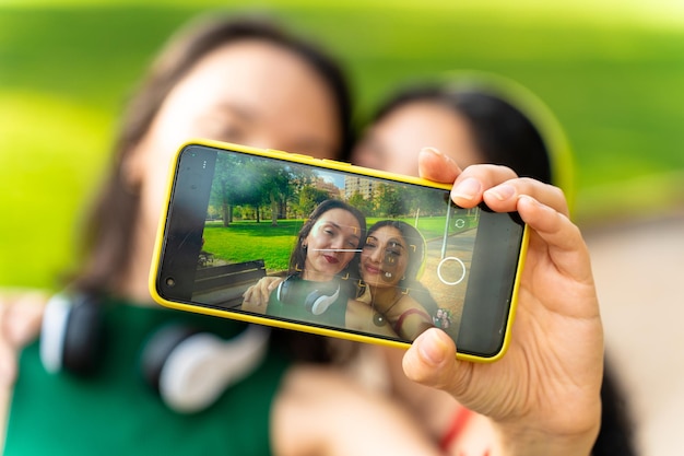 Um casal de amigos interraciais tira uma foto com o telemóvel.