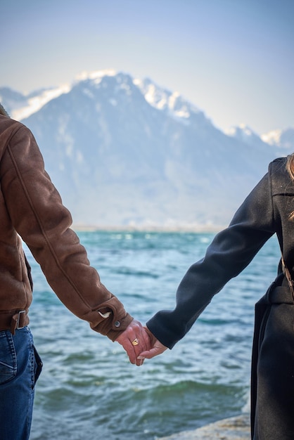 Um casal de braços dados em frente aos alpes suíços