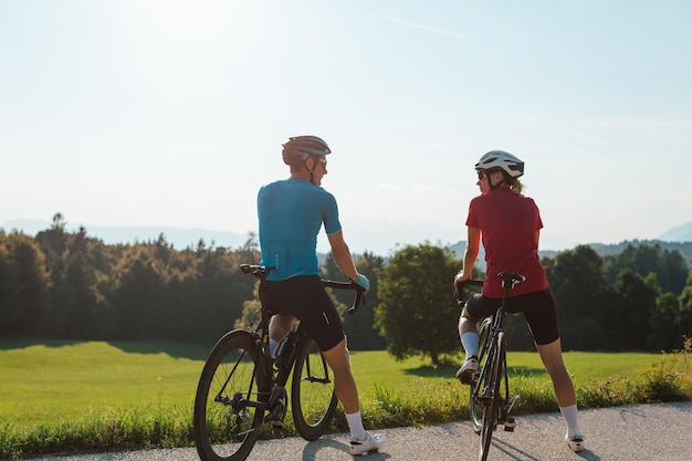 Um casal de ciclistas de corrida a andar no campo.