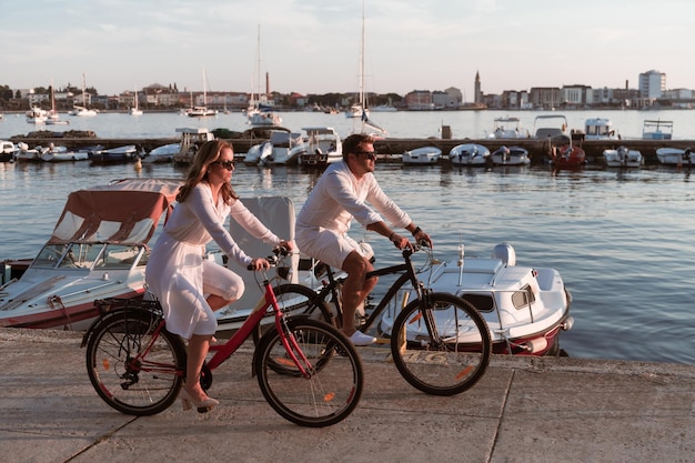 Um casal de idosos a desfrutar de uma bela manhã juntos a andar de bicicleta à beira-mar.