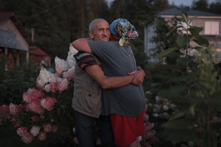 Foto um casal de idosos abraçando-se em meio a plantas
