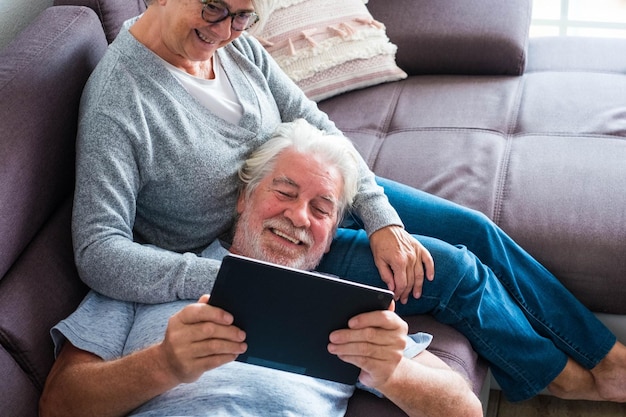 Um casal de idosos aposentados a relaxar em casa.
