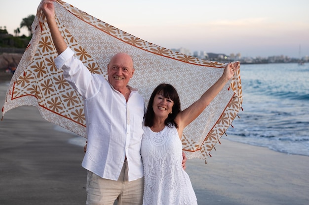 Um casal de idosos despreocupados na praia a desfrutar de férias e aposentadoria.