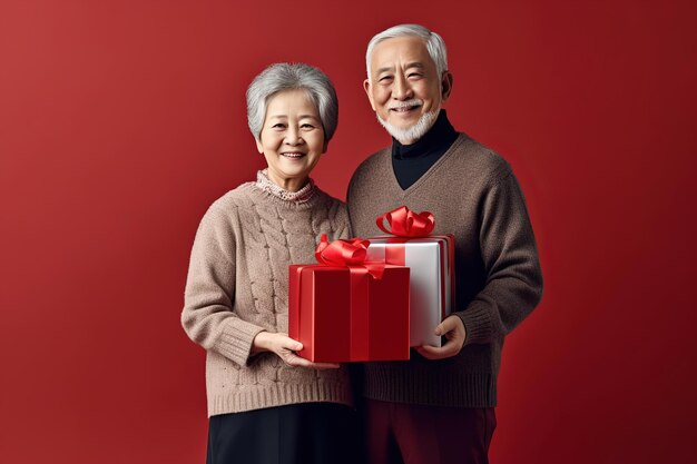 Um casal de idosos segurando uma caixa de presentes