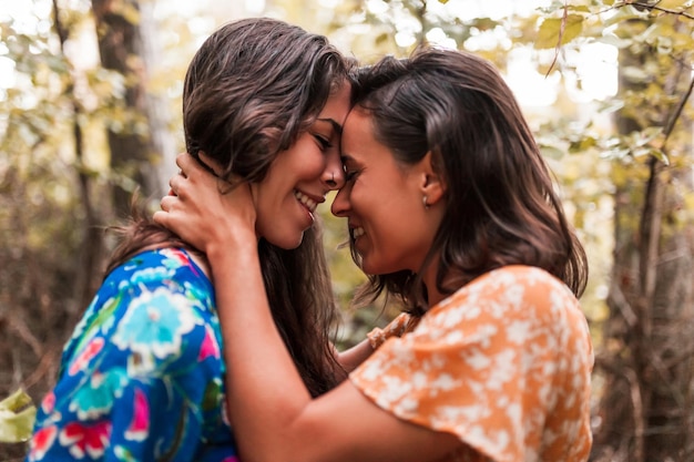 Um casal de lésbicas a abraçar-se na floresta.