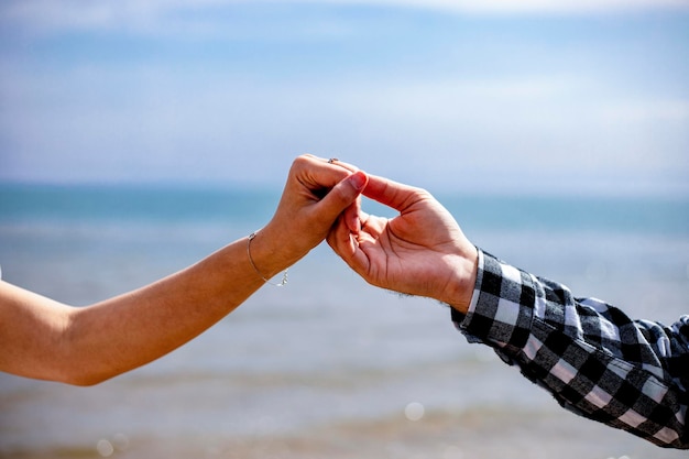 Foto um casal de mãos dadas perto de um mar