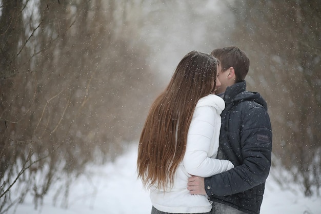 Um casal de namorados em um encontro à tarde de inverno sob uma nevasca